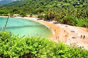 people on a beach on a serene bay