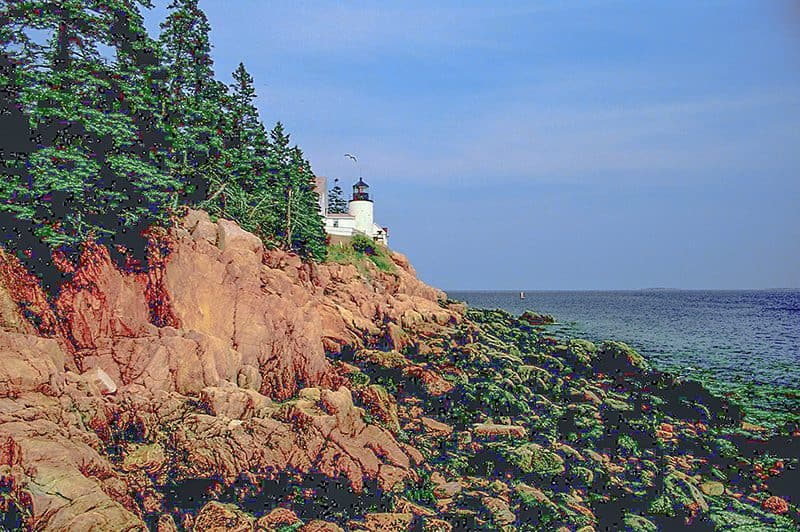 buildings high on a cliff above the ocean