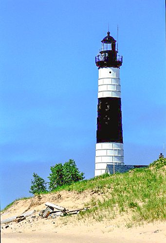 a black and white lighthouse on a beach