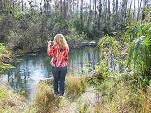 a young woman taking a photo in the Everglades, one of the World Heritage sites in the USA