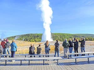 people watching Old Faithful erupt in Yellowstone National PArk