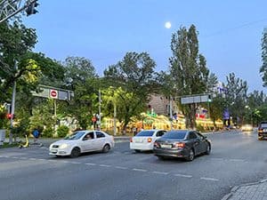 cars on a road at night passing brightkly lit restaurants seen on a visit to almaty kazakhstan