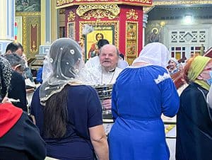 a priest talking to people in a church, seen on a visit to almaty kazakhstan