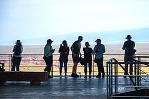 silhouettes of people by a fence