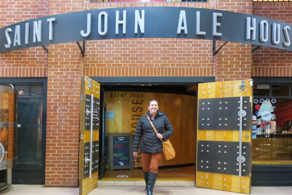 a woman walking out of the Saint John Ale House