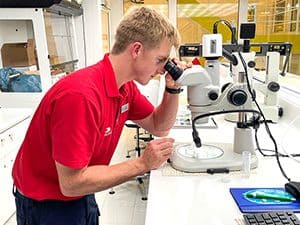 a scientists looking into a microscope aboard the Viking Octantis