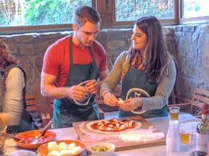 a couple making pizza in a Florence cooking class