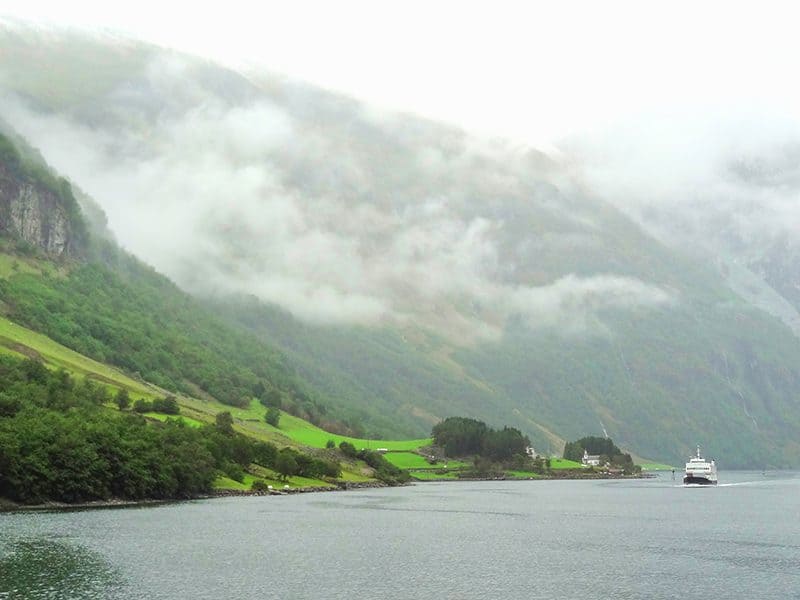a ferry on a fjord with high mountains