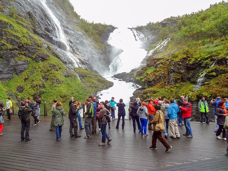 a crowd of people by a waterfall