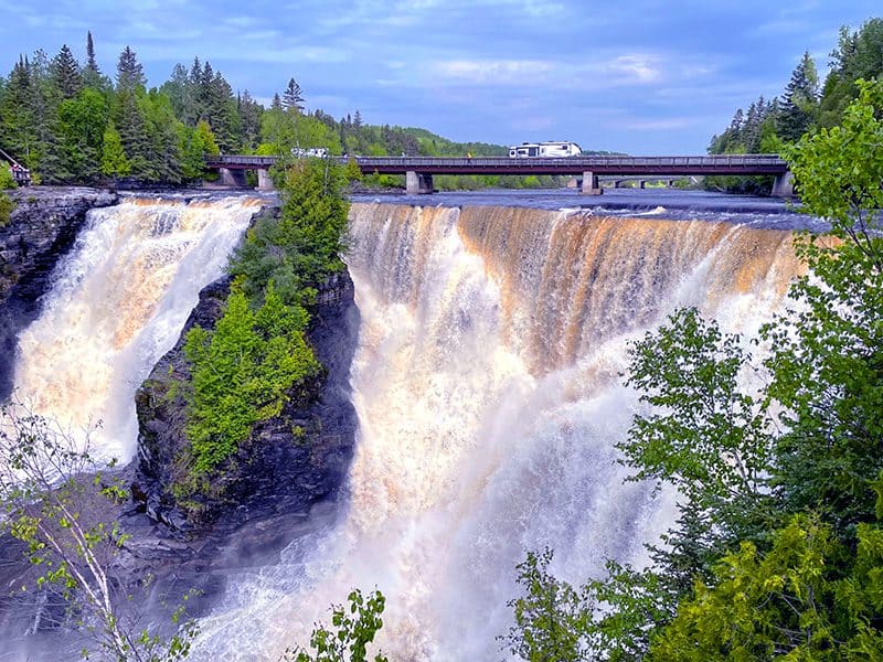 a large waterfall near a bridge