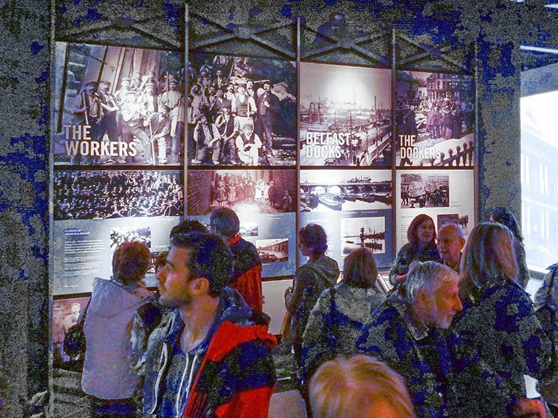 people looking at a poster exhibit in the Titanic Museum Belfast