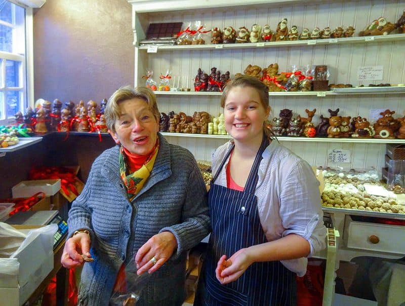 two women in a chocolate shop smiling for the camera