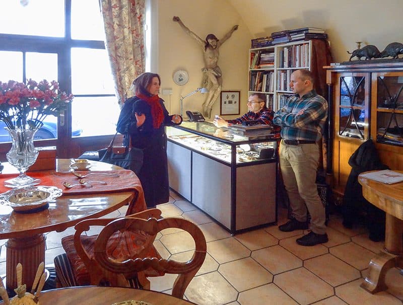 a woman speakin with two men in a shop in one of the hidden gems in Europe