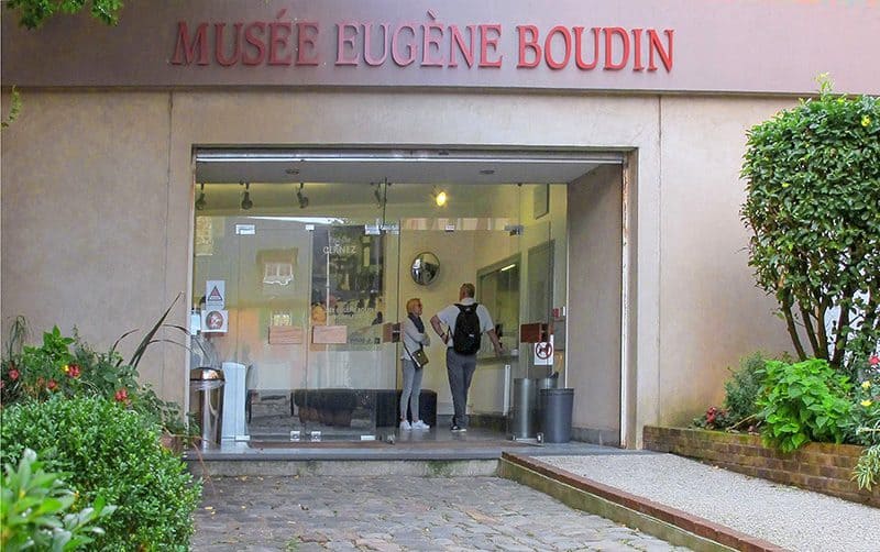 two men talking at the entrance to a museum