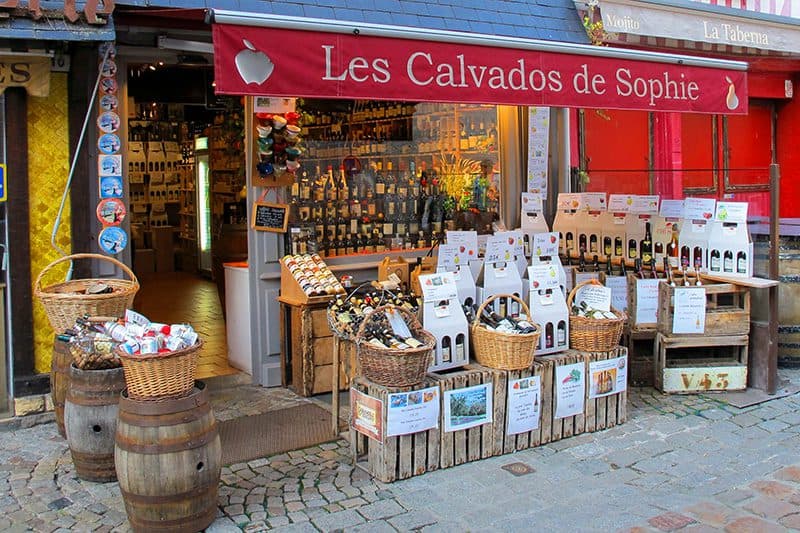 bottles in baskets in front of an old wine shop