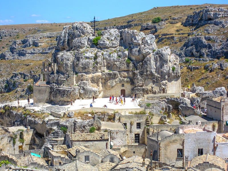 people walking through ancient ruins of the Sassi, an Italian hill town