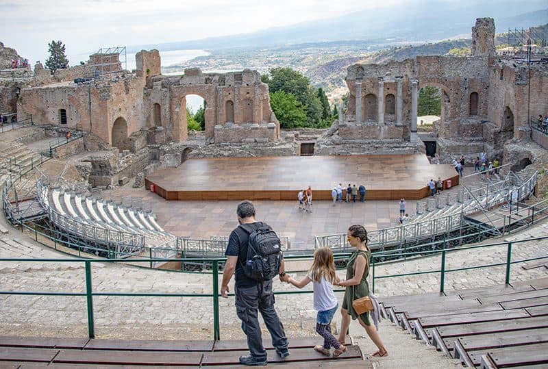 a family walking through an ancient outdoor theater