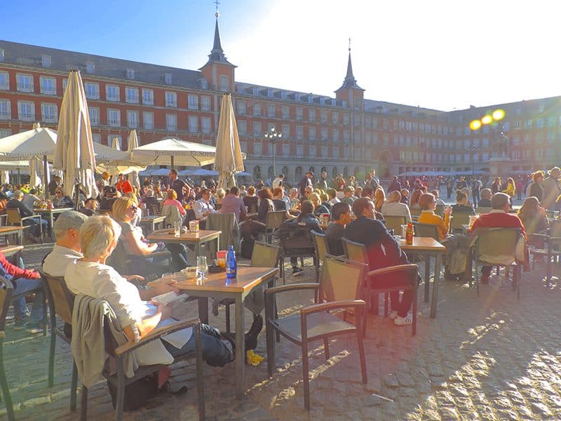 a crowd of people at an outdoor cafe in one of the hidden gems in Europe