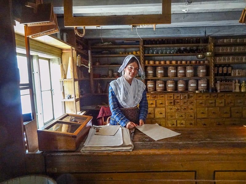 a shopkeeper in period dress in a shop in Sweden