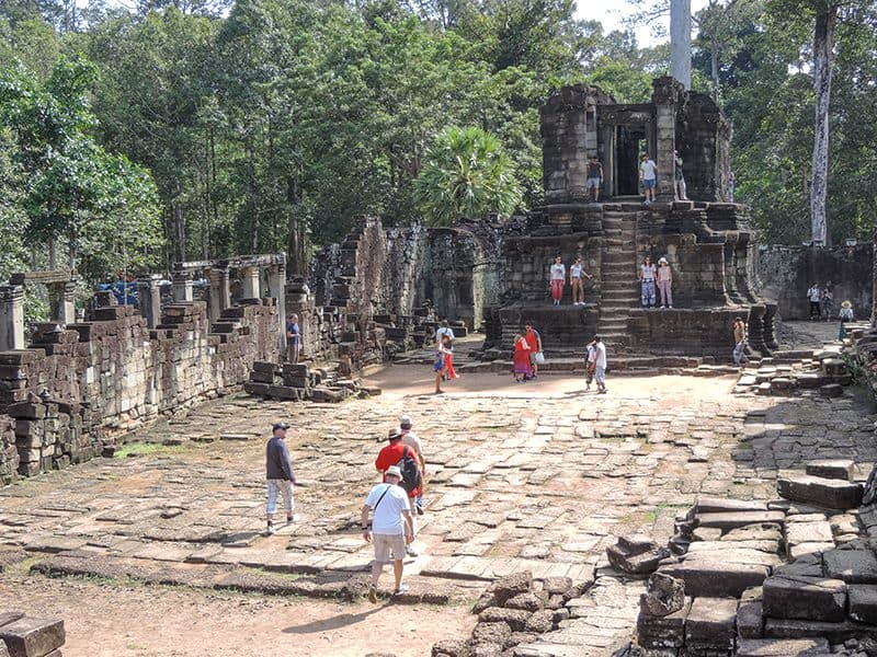 people looking at the ruins of an ancient temple