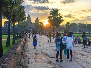 people watching the sunrise while visiting Angkor Wat