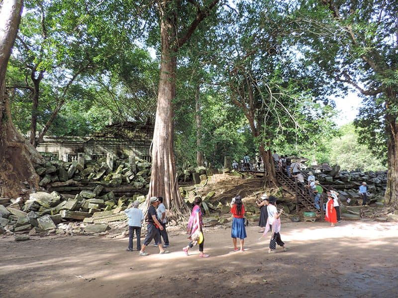 people walking past the ruins of a building