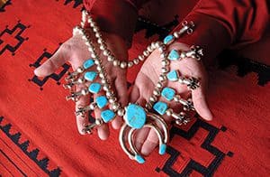 Two hands holding a Turquoise necklace 