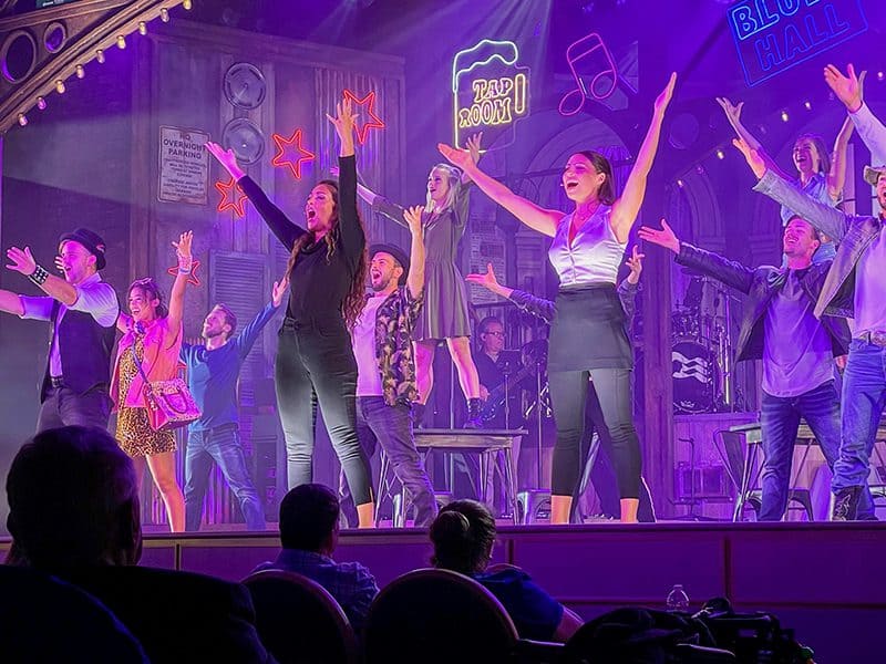 dancers and singers performing in the theater on the Discovery Princess