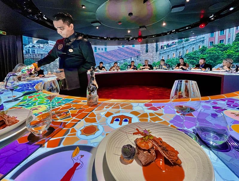 people sitting at a lage round table with an animated tabletop on a Discovery Princess cruise