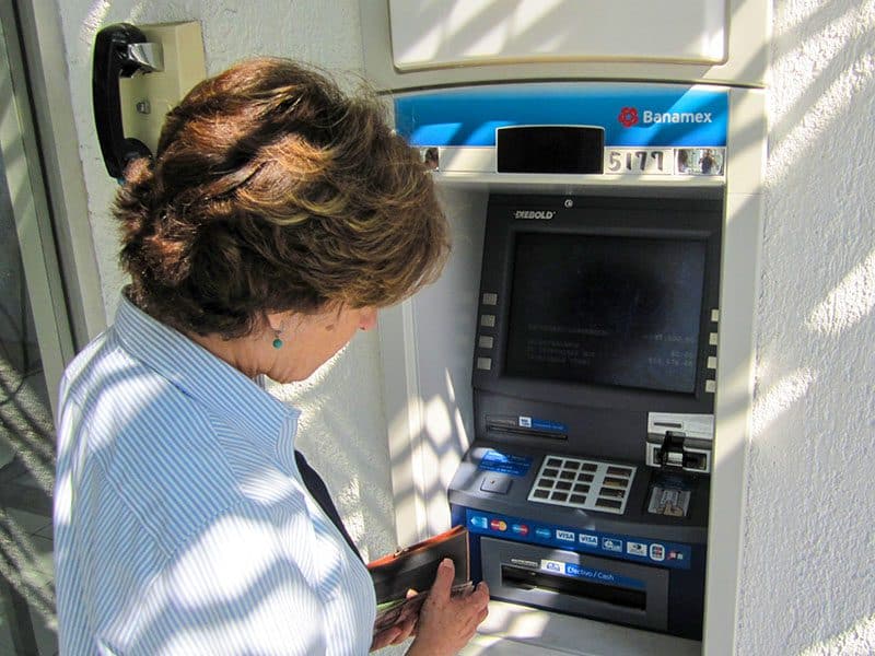 a woman at an ATM -- how to budget for a trip