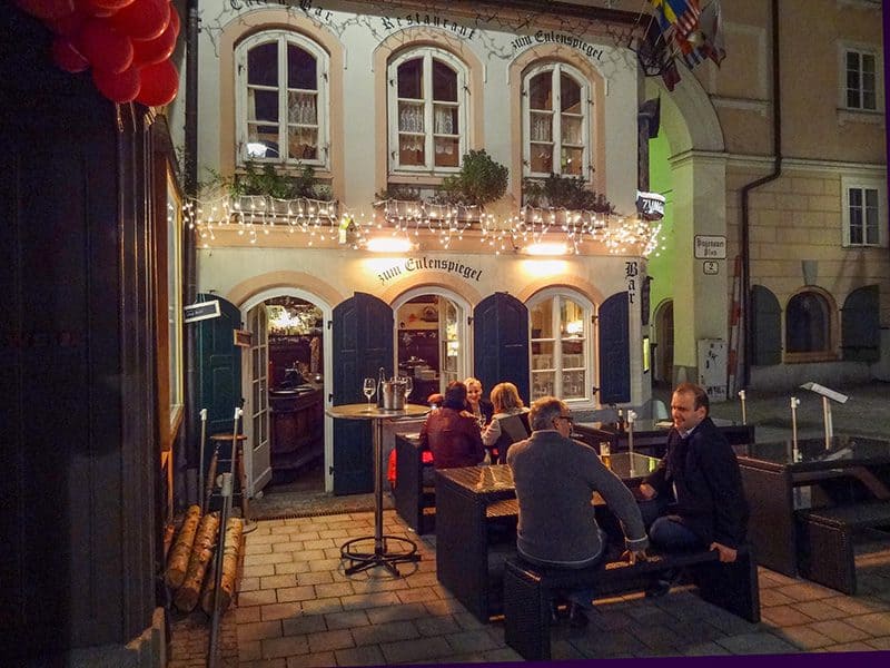 people sitting outside an ld pub at night -- how to budget for a trip