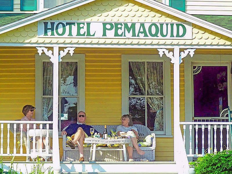 people sitting on the porch of an old hotel -- how to budget for a trip