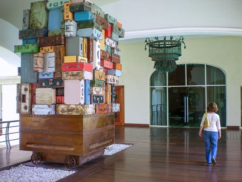an art display of luggage piled high on a cart -- how to budget for a trip