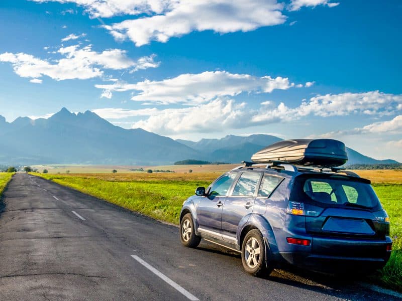 a blue car on the side of a road