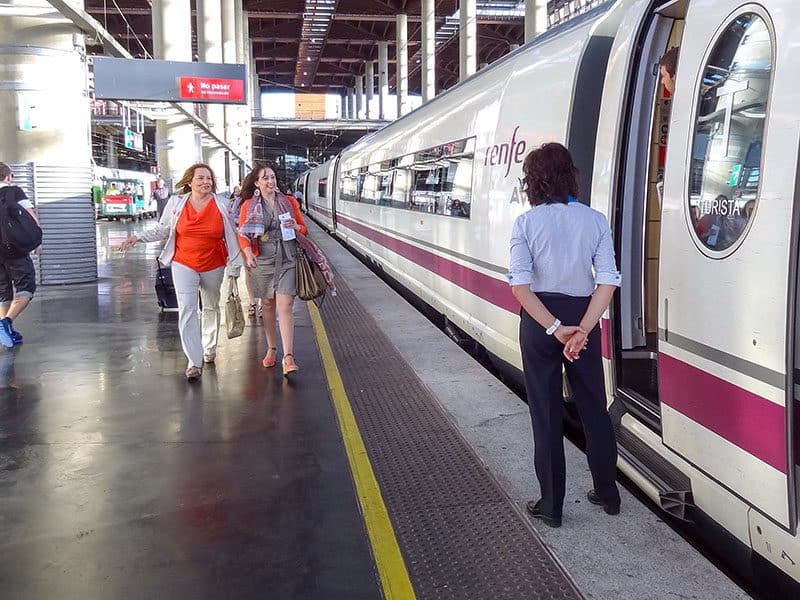 two women walking towards the door of a train