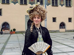 A woman with a fan dressed in 18th-century clothing in Passau Germany