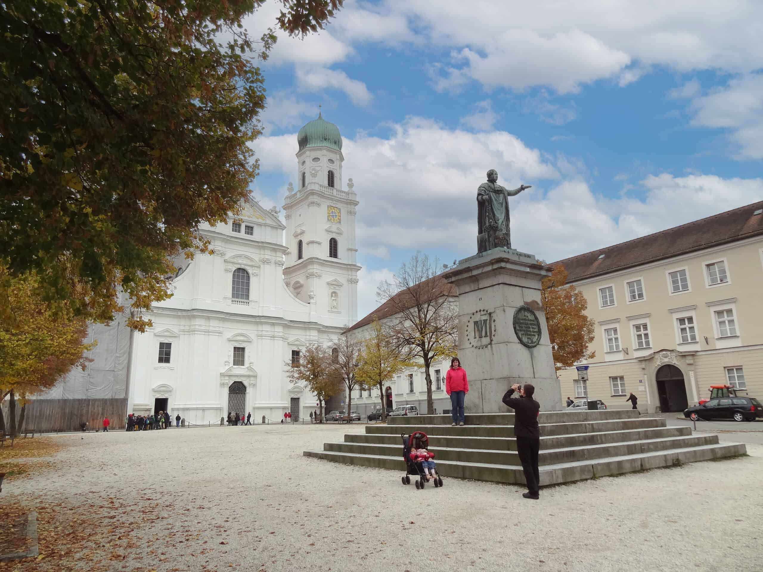 a man taking a photo of a woman in front of a cathedral in Passau Germany