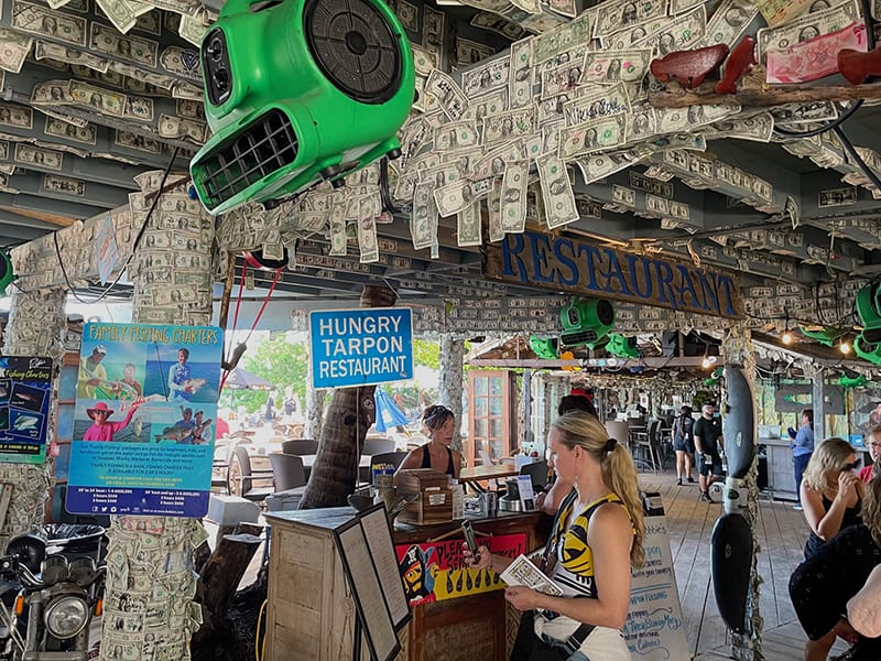 a restaurant with many $1 bills stuck to its ceiling