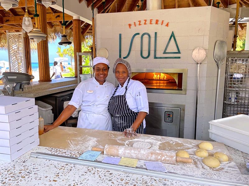 two women making pizzas at a pizza restuarant