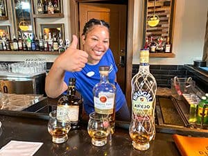 a woman bartender with several bottles of rum