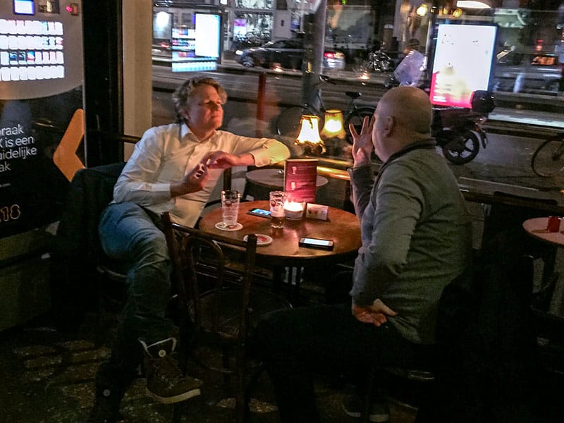 2 men sitting at a table in a pub having a conversation seen during 2 days in Amsterdam