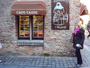 a woman walking towards a cafe - one of things to do in Bruges