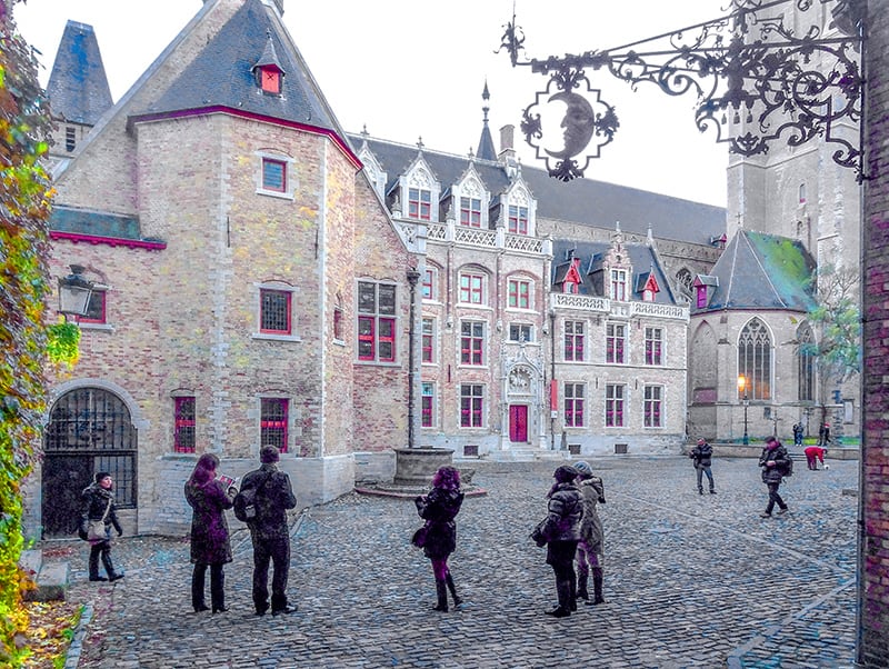 people visiting the courtyard of a Gothic-style building  - one of things to do in Bruges