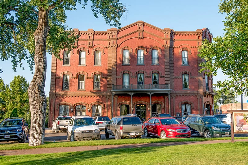 cars parked in front of an old hotel