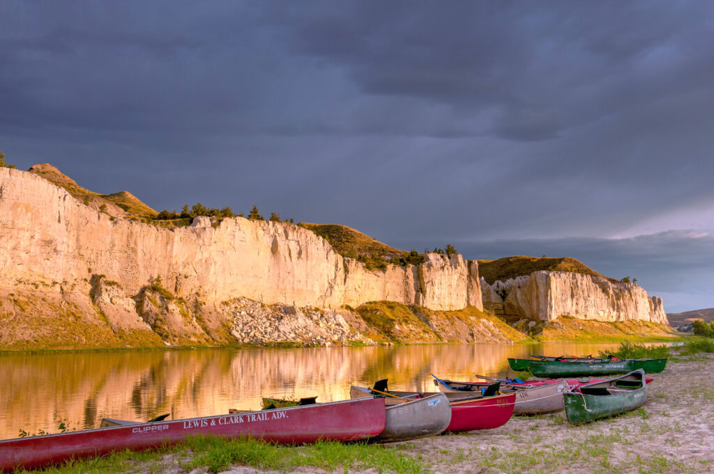 canoes beached near white cliffs at sunset near Fort Benton MT