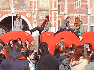 people sitting atop a large red sign