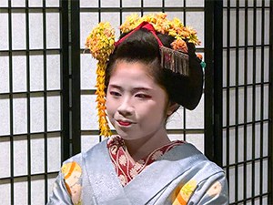 a geisha with yellow flowers in her hair