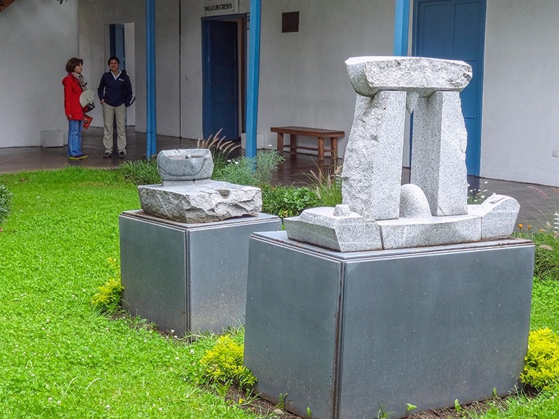 two women looking a sculpture in an outdoor museum - - one of the things to do in Cuenca