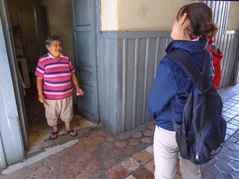 a woman in a blue jacket speaking with a short woman