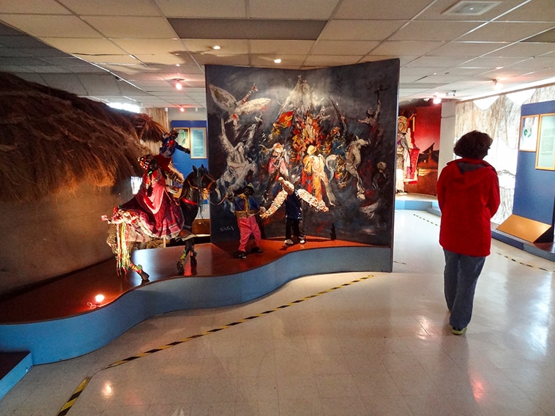 a woman near a brightly colored diorama in a museum - - one of the things to do in Cuenca